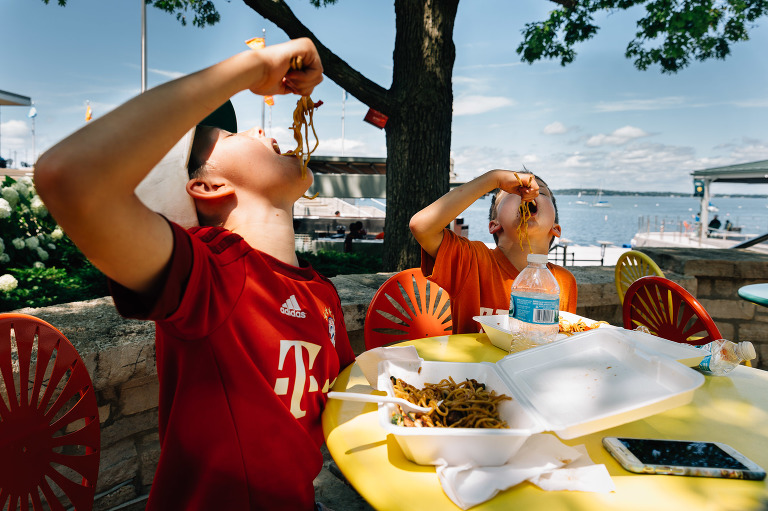 Boys eat noodles with chopsticks 