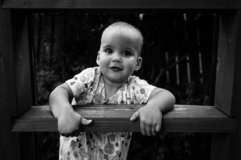 Toddler girl climbs ladder, black and white 