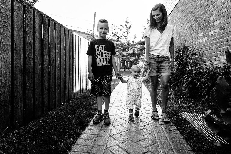 Mom, son and daughter walk along path at home