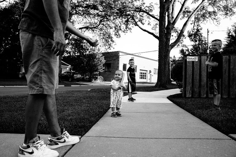 Family teaches toddler girl to hit baseball