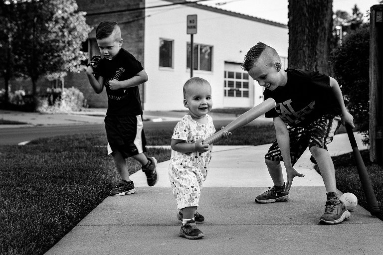 Toddler girl hits ball and brothers and brothers move into position to get her out