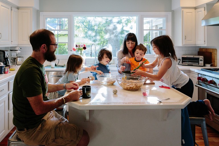 Documentary photography for whole family baking apple cake in the kitchen together 