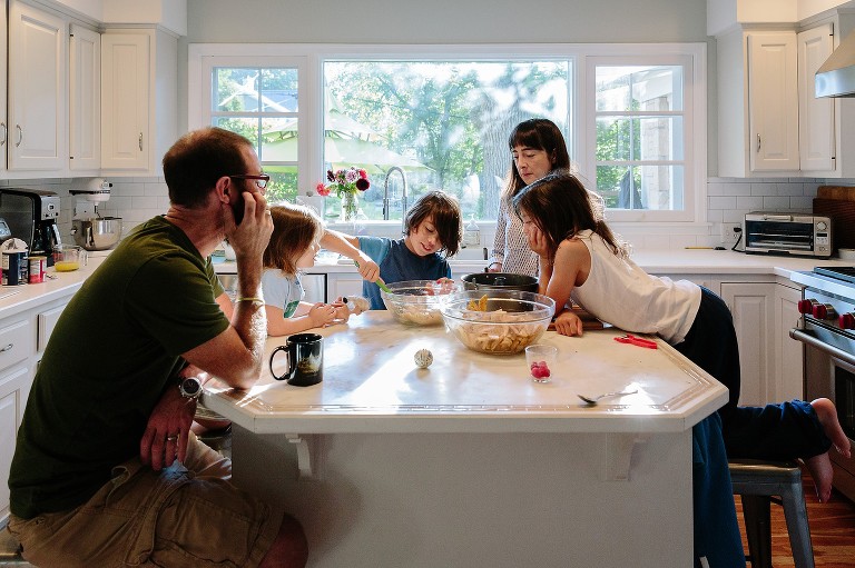 Oldest boy takes a turn stirring the heavy apple batter. Documentary photography 