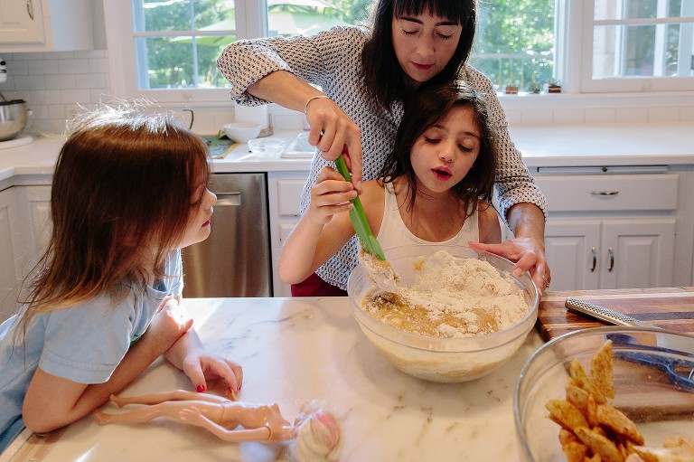 Mom helps daughter stir the heavy cake batter 
