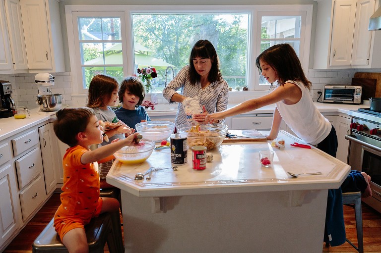 Mom measures sugar. All kids present and working in kitchen 