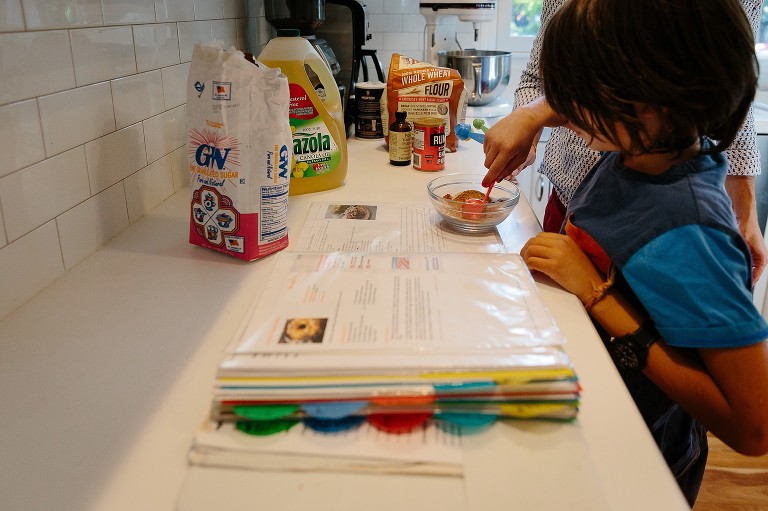Older son follows directions and measures out cinnamon 