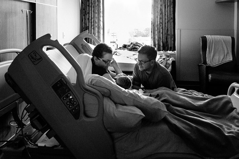 Mom and Dad look at newborn in hospital 