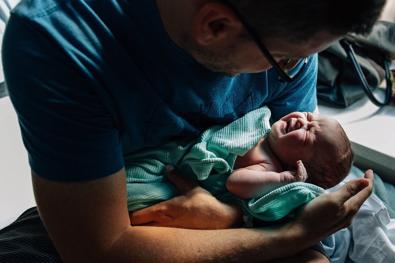 Newborn cries and dad comforts her 