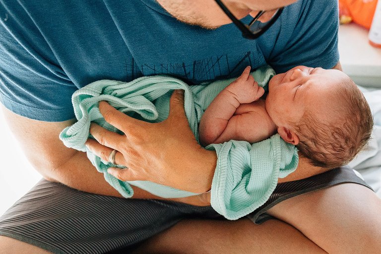 Newborn sleeps in dad's arms at hospital 