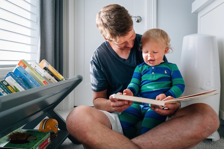 Dad reads book to toddler son 