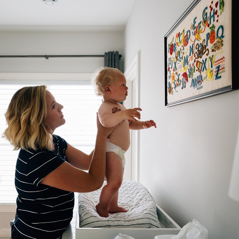 Toddler looks at alphabet art getting ready for bed 