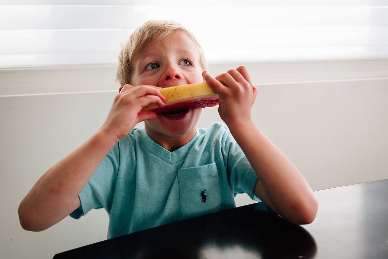 Boy takes big bite of watermelon 