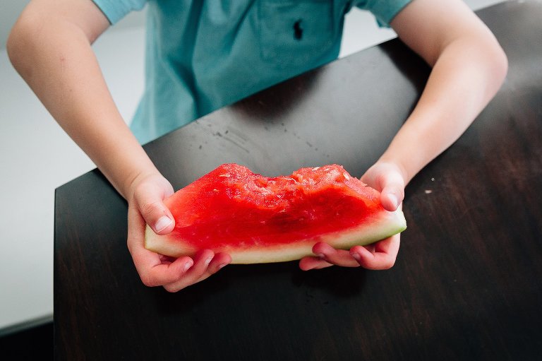 Boy holds watermelon in his hands 