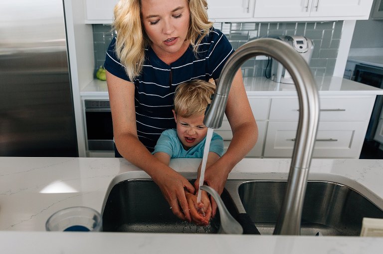 mom helps preschool son wash his hands 