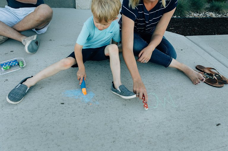 Mom and preschool son write with sidewalk together