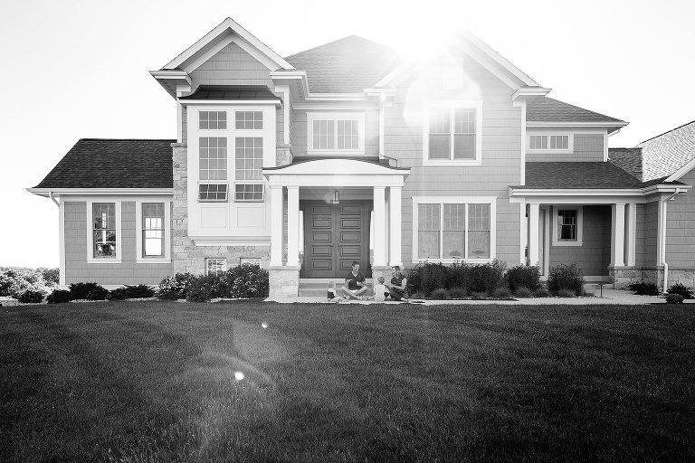 Family plays with chalk and bubbles in front of family home