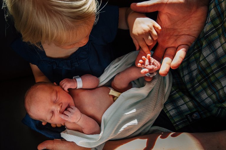Big sister checks out newborn toes