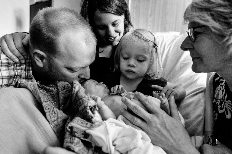 Whole family, including grandma, squeeze in to see new baby