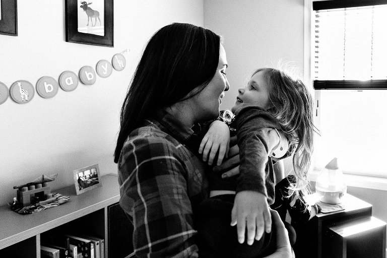 Mom and young daughter snuggle inside 