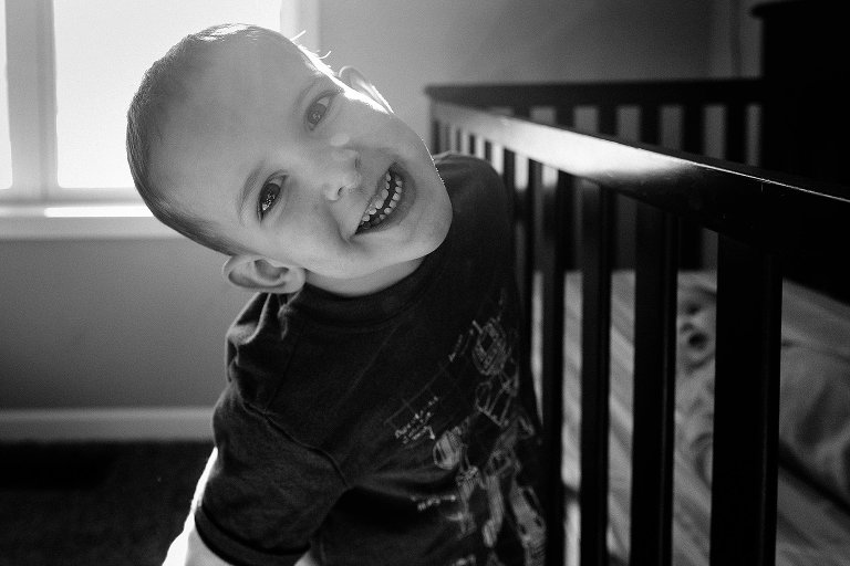 Boy smiles in baby's room 