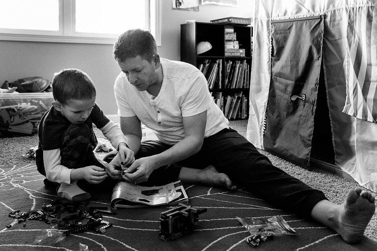 Dad and son build Legos together 
