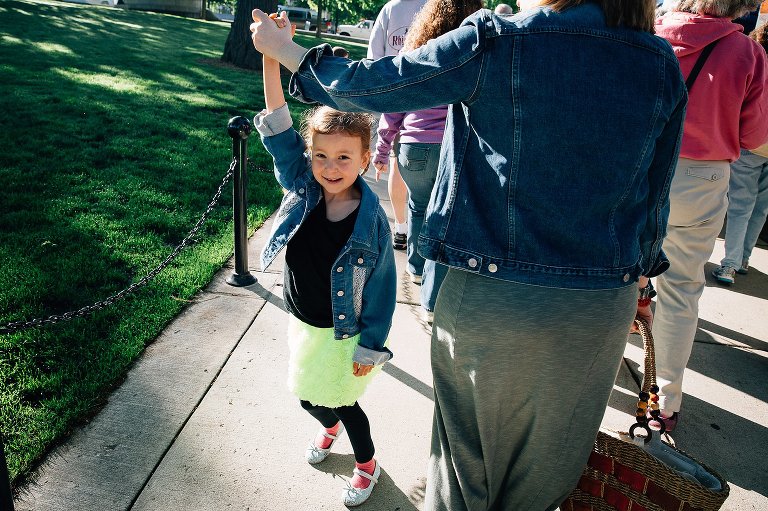 Mom twirls young daughter at crowded farmers market