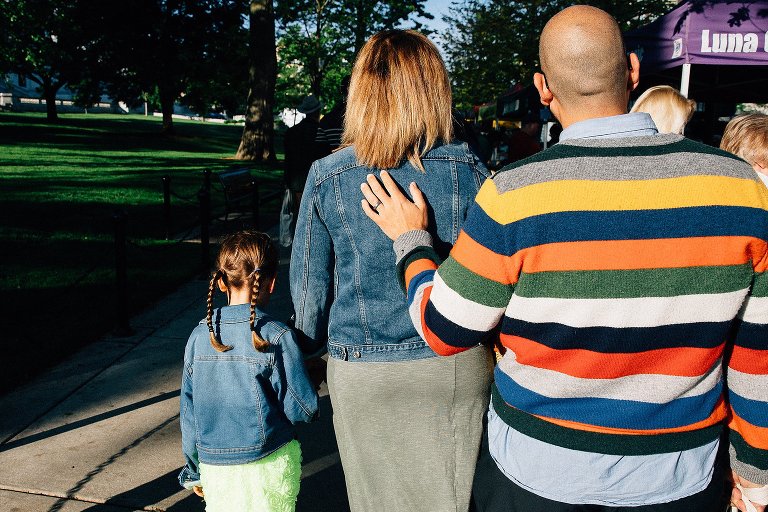 Dad puts hands on wife's back as they walk through Wisconsin Farmer's Market together