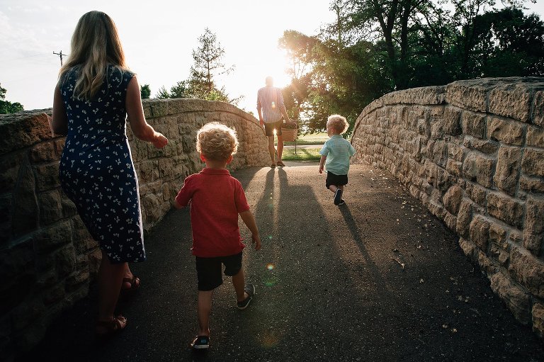 Family crosses bridge in late summer light. 