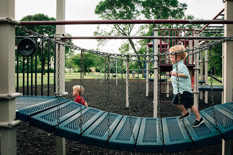 Tow boys play on playground equipment 
