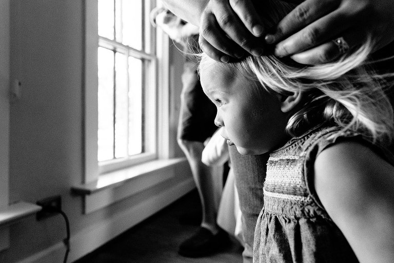 Fan blows toddler's hair. 