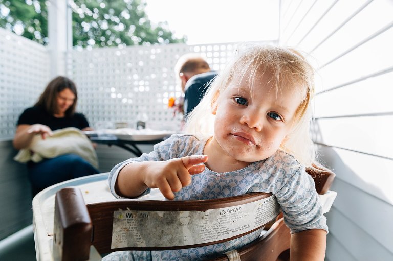 Portrait of toddler daughter, parents and newborn sibling min background. 