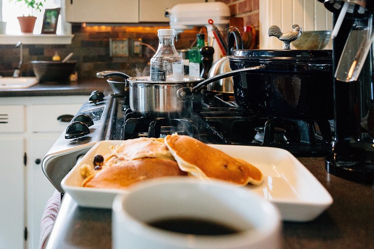 Steam surrounds bottle of syrup on stove that is warming. 