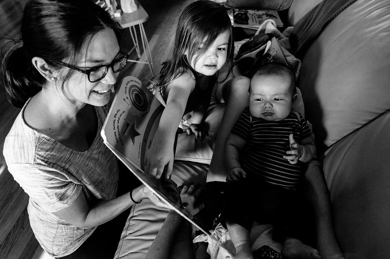 girl points to book a mothers is holding 