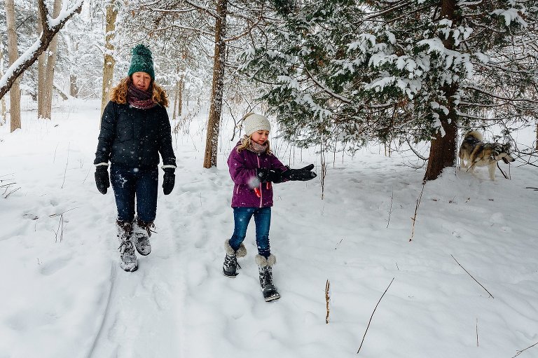Mothers and daughter walk in a snowy forest together