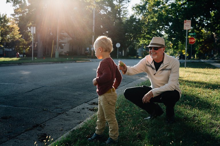 Grandpa gives preschool grandson a walnut to hold. 