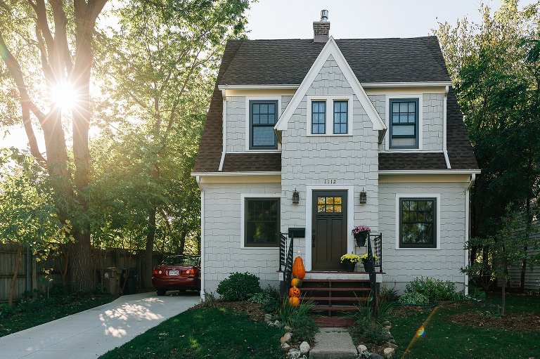two story house in the fall with afternoon sun coming through the trees