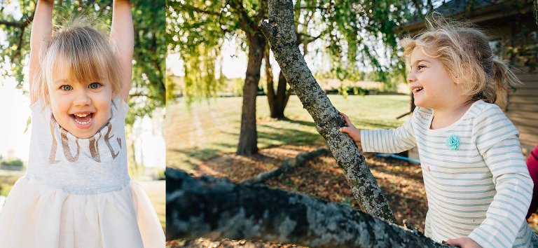 Older girl hangs from a tree, young girl climbs a tree in the backyard. They are both smiling and the evening light is soft. 