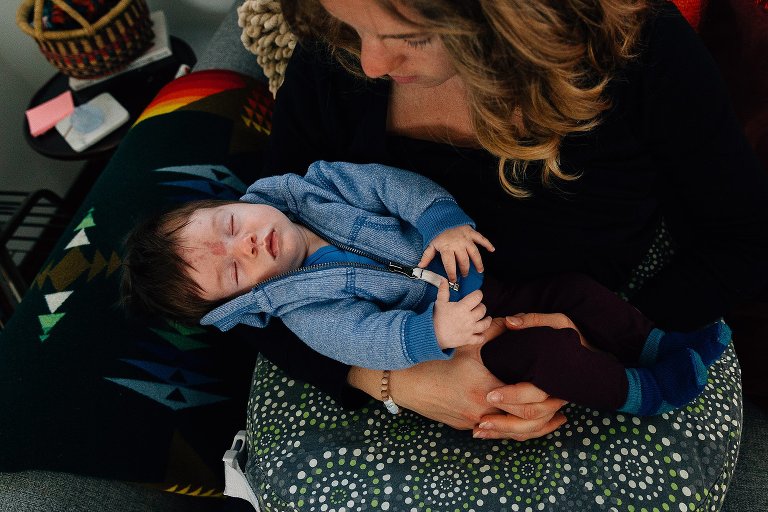 Baby girl is asleep in her mother's arms. Top down view. 