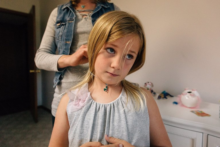 Mother clasps necklace around daughter's neck.