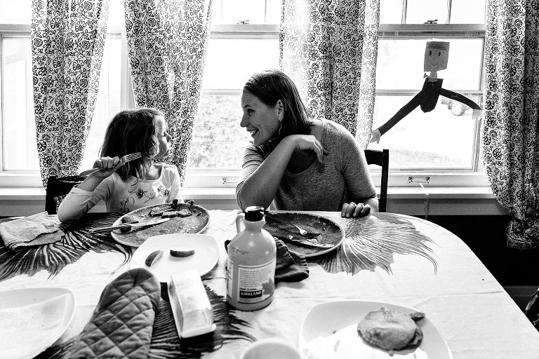 Black and white. Mom and daughter have a conversation at the breakfast table. 