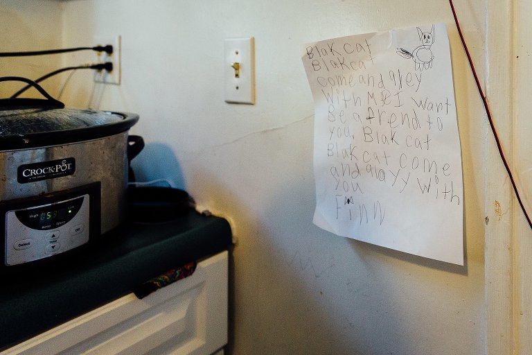 A poem about "Black Cats" written by a first grader is taped to the kitchen wall. 