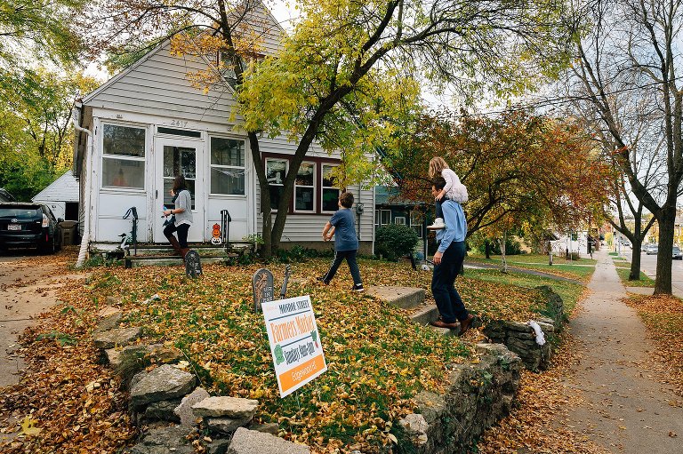 Fall. Family of four walk home. Fall leaves are everywhere. 
