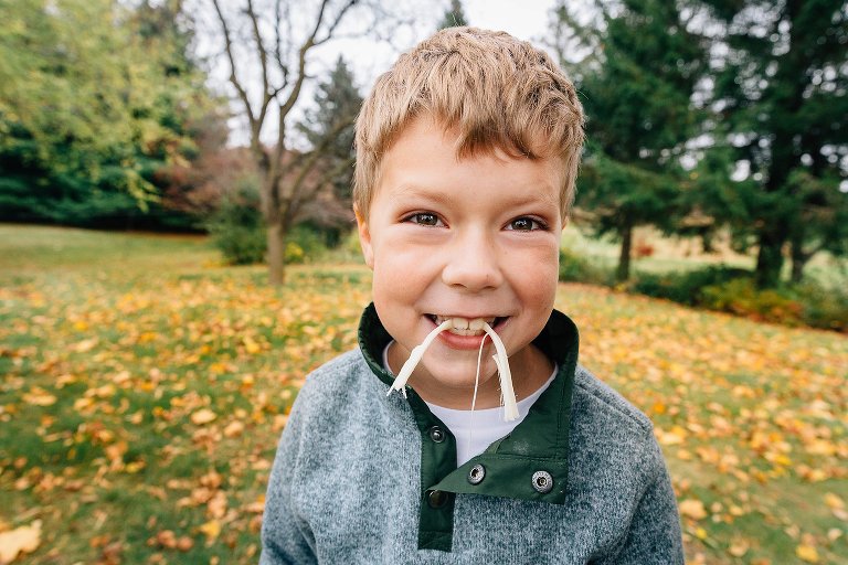Boy eats string cheese. 