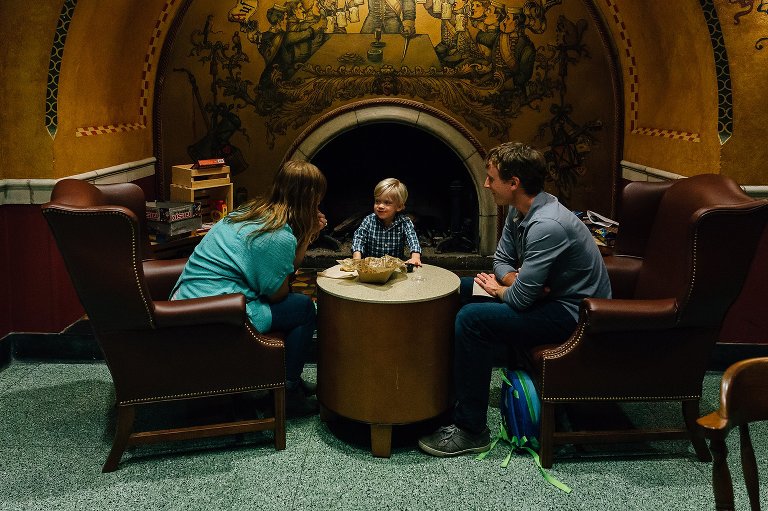 Mother, father, and son sit around table eating snacks.