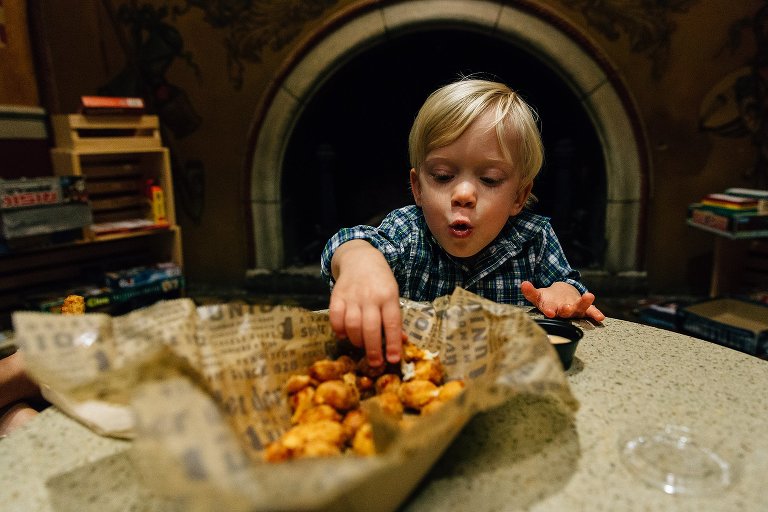 Little boy blows to cool down deep fried cheese curds.