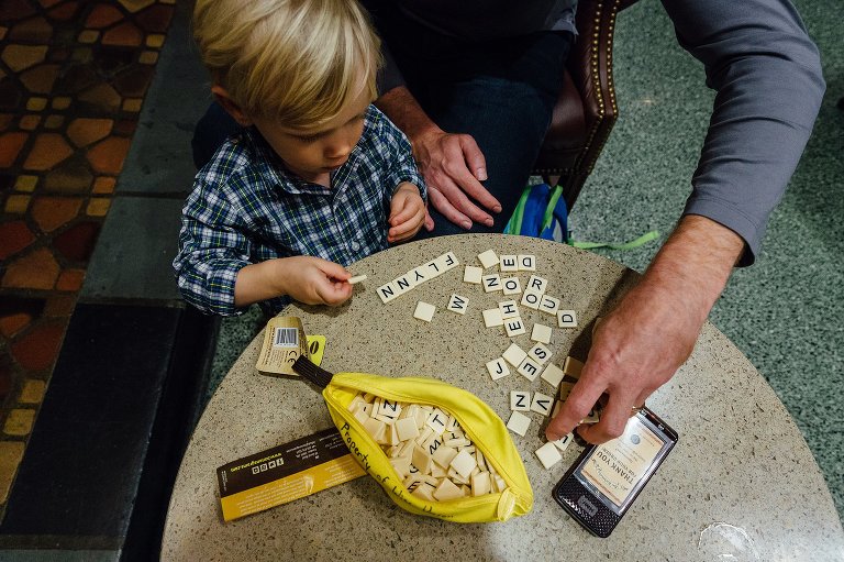 Father and son play bananagrams on table.
