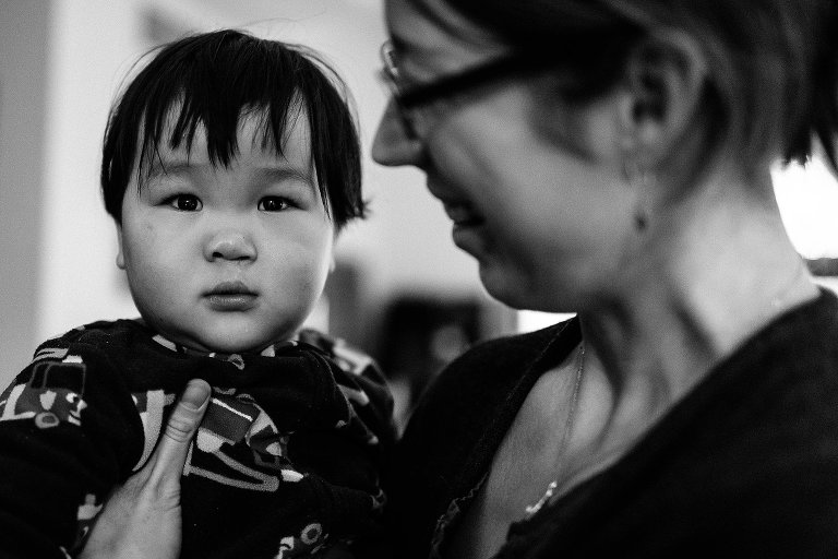 Black and white. Mother holds little boy.