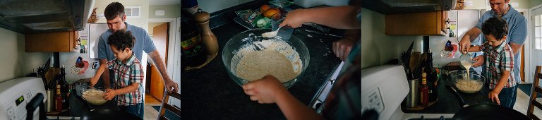 Father in kitchen with toddler son standing on chair mixing pancake batter.
