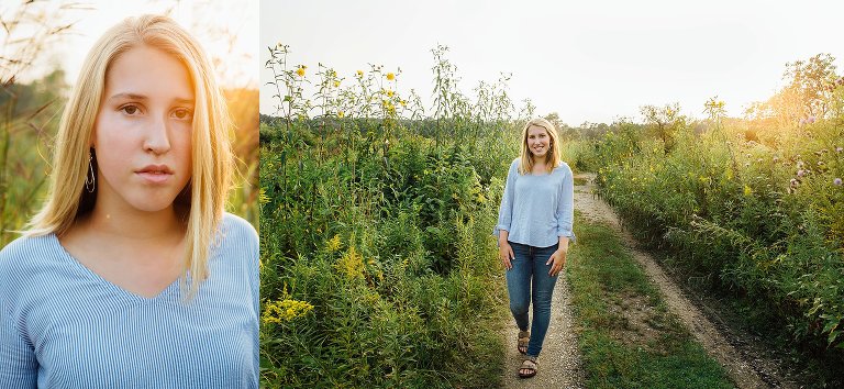 High school senior makes eye contact with warm sun flare entering frame, she makes a serious face. Girl walks down a lane of flowers as sun sets on the right of the frame.