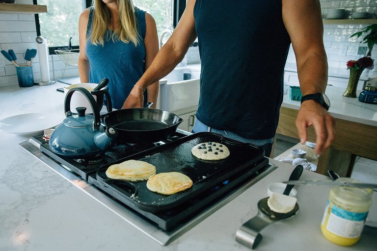 Dad makes a blueberry pancakes breakfast for the family.